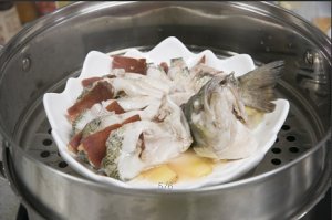 將鱸魚成花狀擺好，將火腿切片放入各縫隙中，放入鍋中隔水蒸12分鐘拿出，撒上蔥花即可。